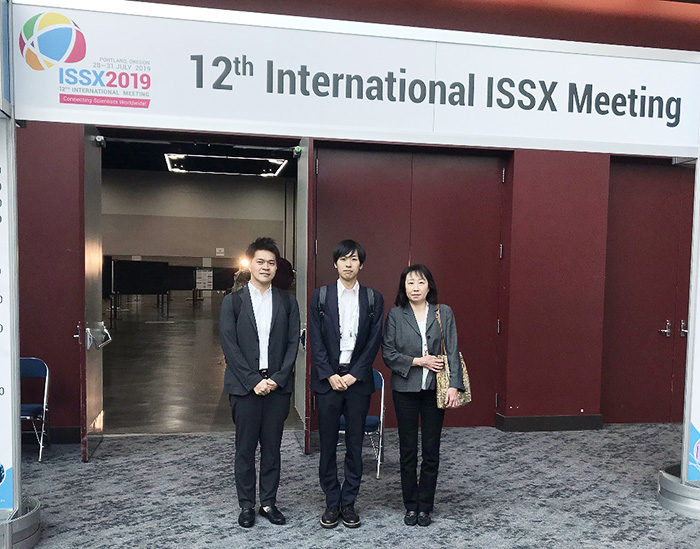 12th International ISSX Meetingのゲート前で3人並んで写っている写真